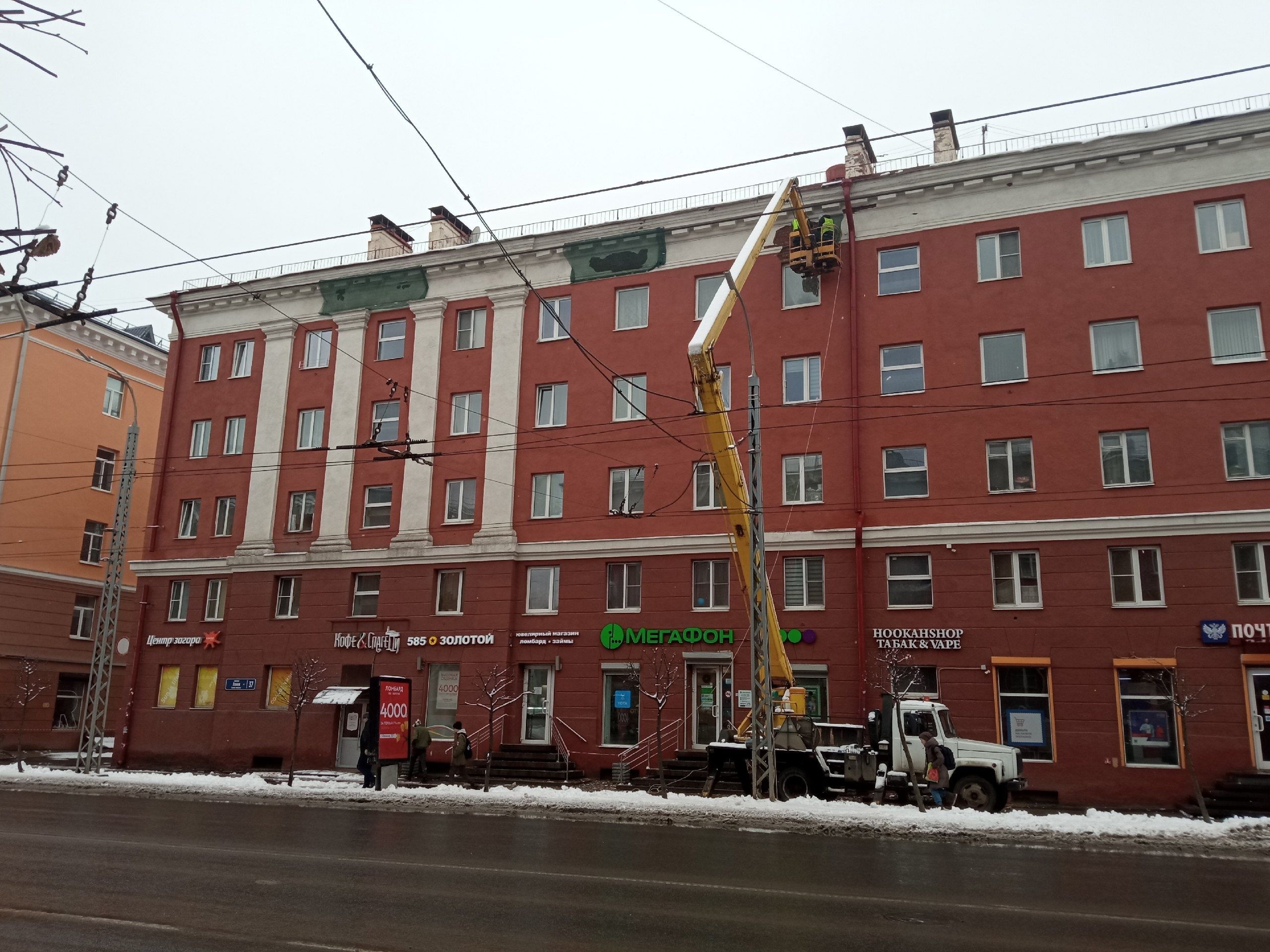 Рабочие укрепляют лепнину на доме в центре Петрозаводска