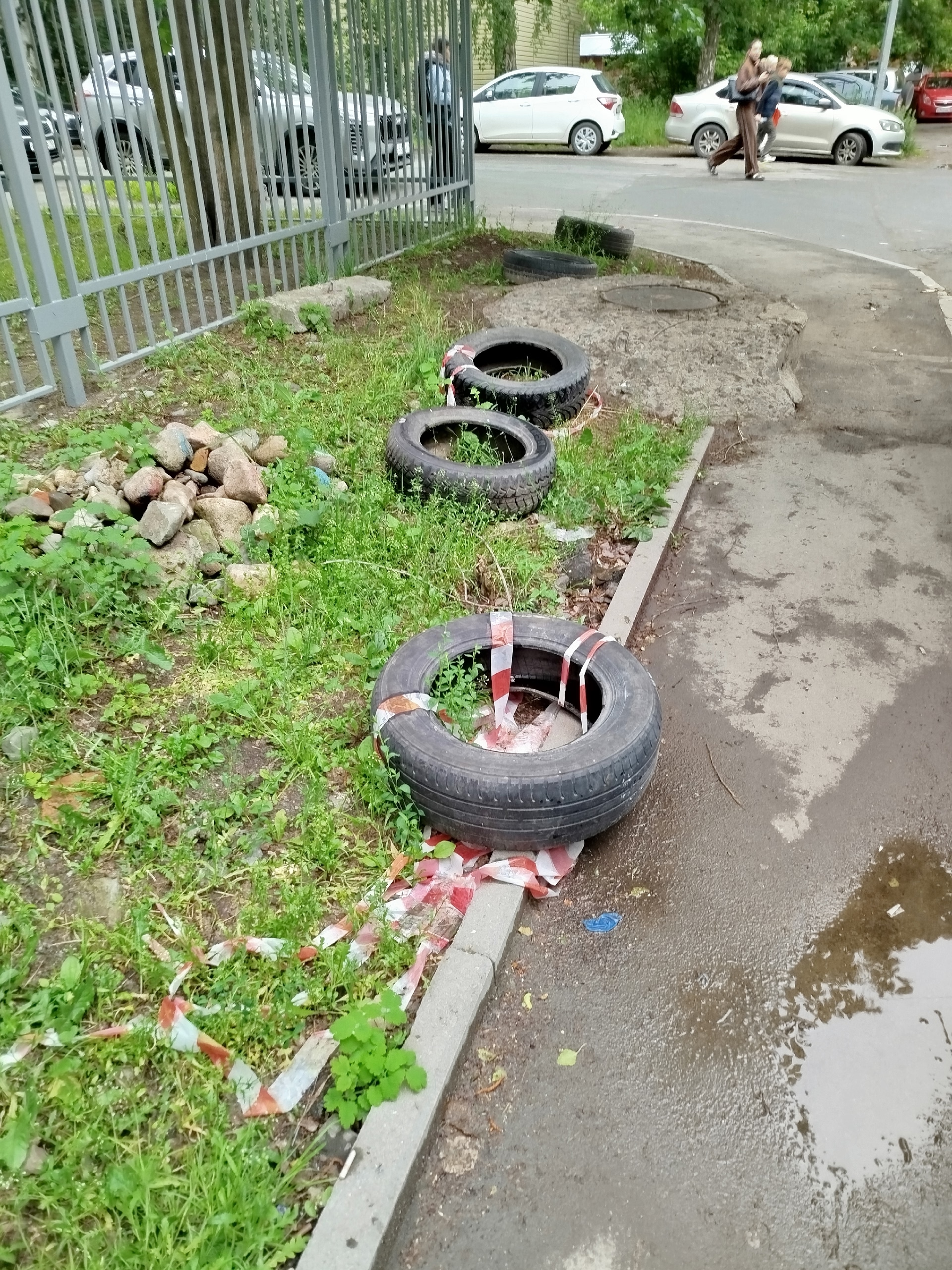 Рабочие сделали забор из старых колес рядом с садиком в центре Петрозаводска